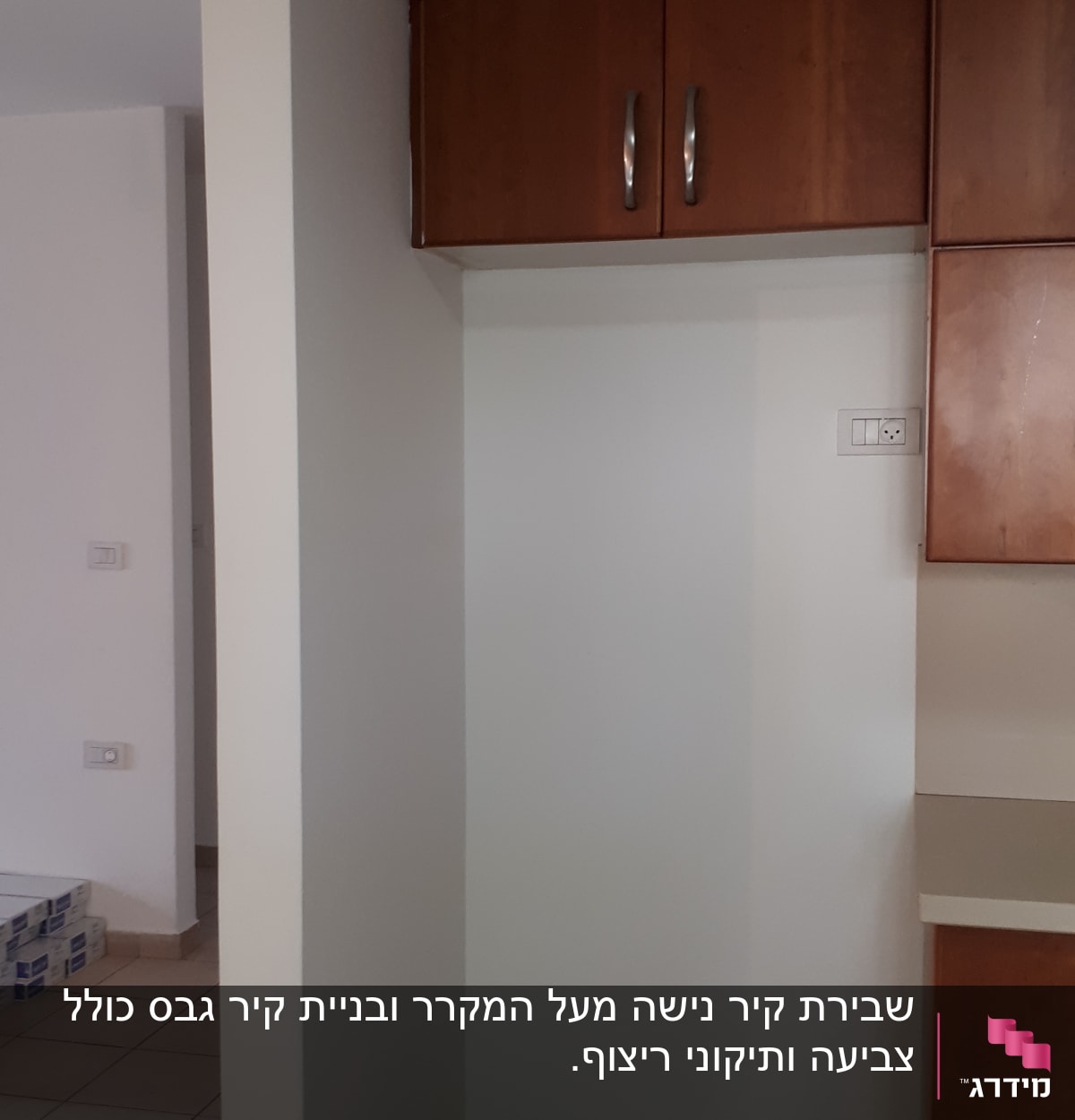 ארונות עץ על קיר לבן עם שקע חשמל